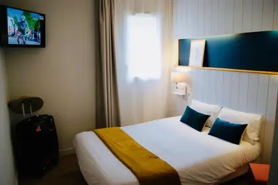 Un ou plusieurs lits dans un hébergement de l'établissement Logis Hôtel L'Air Marin