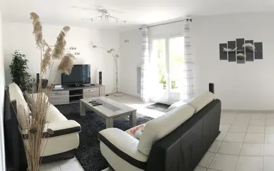 Télévision ou salle de divertissement dans l'établissement Maison contemporaine au calme avec jardin arboré
