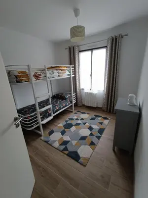Un ou plusieurs lits dans un hébergement de l'établissement Maison de vacances avec jardin