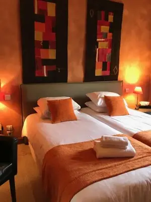 Un ou plusieurs lits dans un hébergement de l'établissement Logis hotels Les Glycines