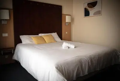 Un ou plusieurs lits dans un hébergement de l'établissement Logis Hôtel & Restaurant Le Cheval Blanc et Clovis