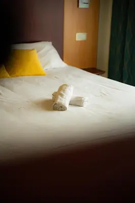 Un ou plusieurs lits dans un hébergement de l'établissement Logis Hôtel & Restaurant Le Cheval Blanc et Clovis
