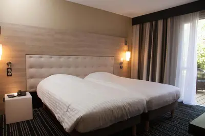 Un ou plusieurs lits dans un hébergement de l'établissement Logis LE RABELAIS Hôtel- Restaurant - SPA