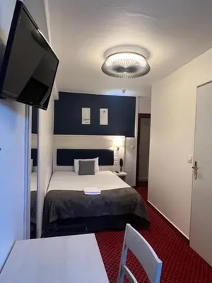 Un ou plusieurs lits dans un hébergement de l'établissement Brit Hotel Bleu Nuit