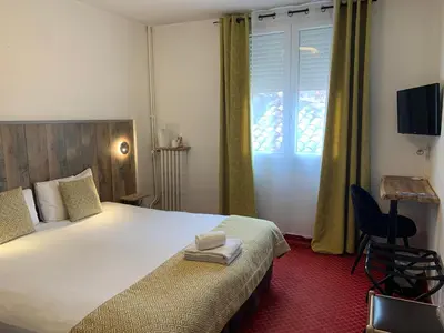 Un ou plusieurs lits dans un hébergement de l'établissement Brit Hotel Bleu Nuit