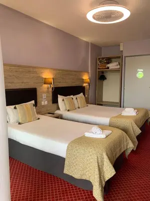 Un ou plusieurs lits dans un hébergement de l'établissement Brit Hotel Bleu Nuit