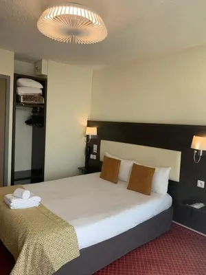 Un ou plusieurs lits dans un hébergement de l'établissement Brit Hotel Bleu Nuit