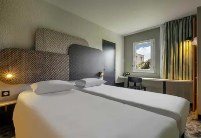 Un ou plusieurs lits dans un hébergement de l'établissement B&B HOTEL Niort Sud Venise Verte