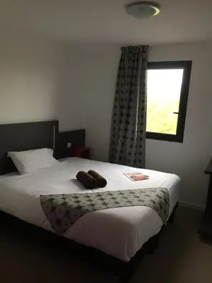 Un ou plusieurs lits dans un hébergement de l'établissement Kyriad Direct La Rochelle Aytré