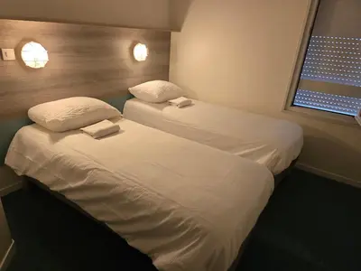 Un ou plusieurs lits dans un hébergement de l'établissement Brit Hotel Essentiel Poitiers Gare du Futuroscope