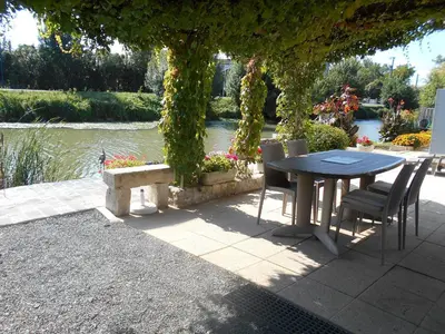 Jardin de l'établissement MARAIS POITEVIN bord rivière pêche ,barque, vélos, wifi, linge, cheminée, cuisine, terrain de boules