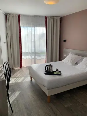 Un ou plusieurs lits dans un hébergement de l'établissement Hôtel Au Relais des Lilas