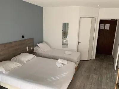 Un ou plusieurs lits dans un hébergement de l'établissement Hôtel Au Relais des Lilas