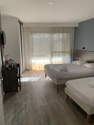 Un ou plusieurs lits dans un hébergement de l'établissement Hôtel Au Relais des Lilas