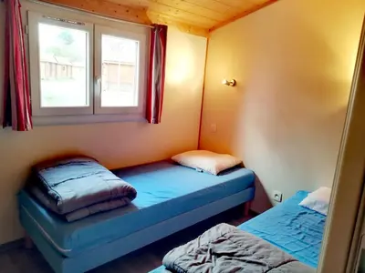 Un ou plusieurs lits dans un hébergement de l'établissement Camping Ushuaïa Village Les Chalets de Moulière