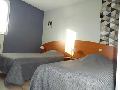 Un ou plusieurs lits dans un hébergement de l'établissement LOGIS Hôtel LES 3 MARCHANDS