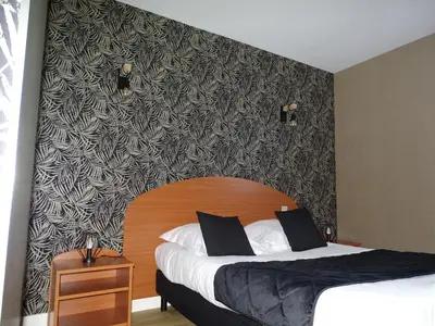 Un ou plusieurs lits dans un hébergement de l'établissement LOGIS Hôtel LES 3 MARCHANDS