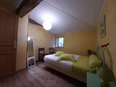 Un ou plusieurs lits dans un hébergement de l'établissement Gîte cosy avec 3 chambres, cour privée, baby-foot et internet, équipements bébé inclus, animaux permis - FR-1-653-154